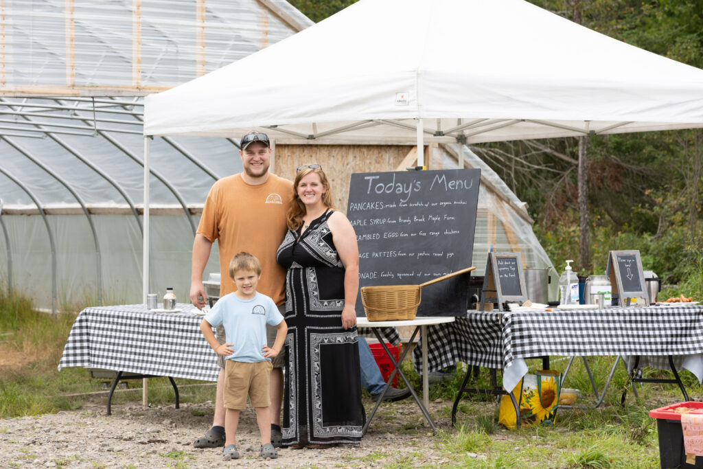A family stands in front of an outdoor kitchen.