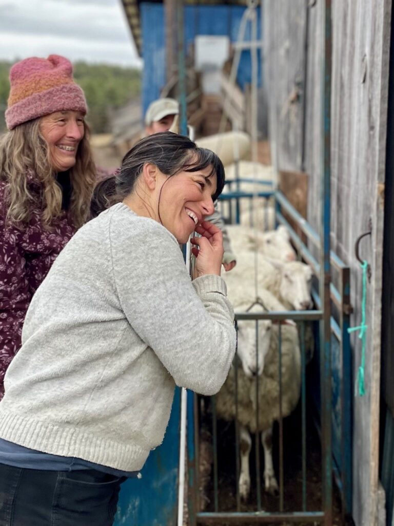 Women interacting with goats in a farm setting
