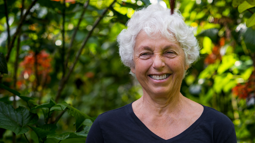 Elderly woman smiling in a garden