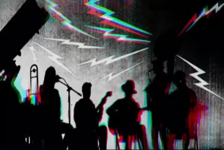Silhouetted band performing with colorful prism lights