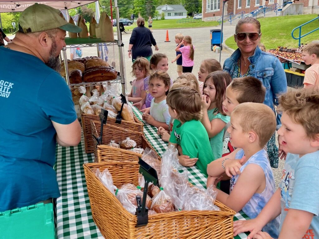 Children buying bread at outdoor market