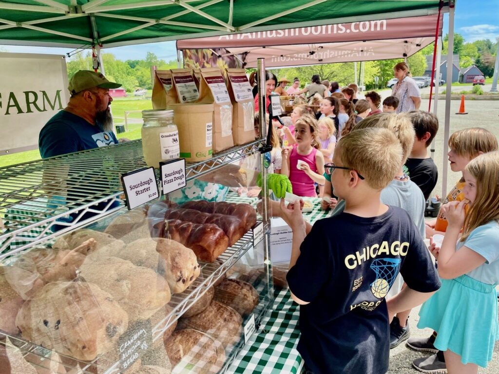 Farm stand with sourdough bread and customers