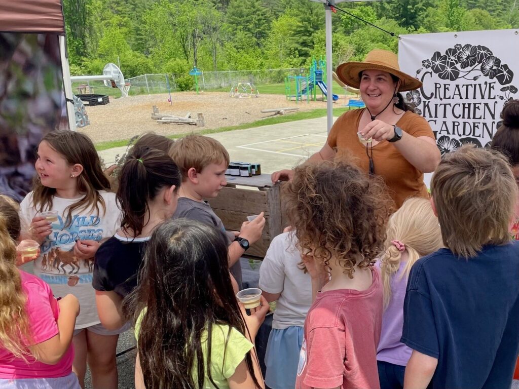 Children sampling food at outdoor garden event