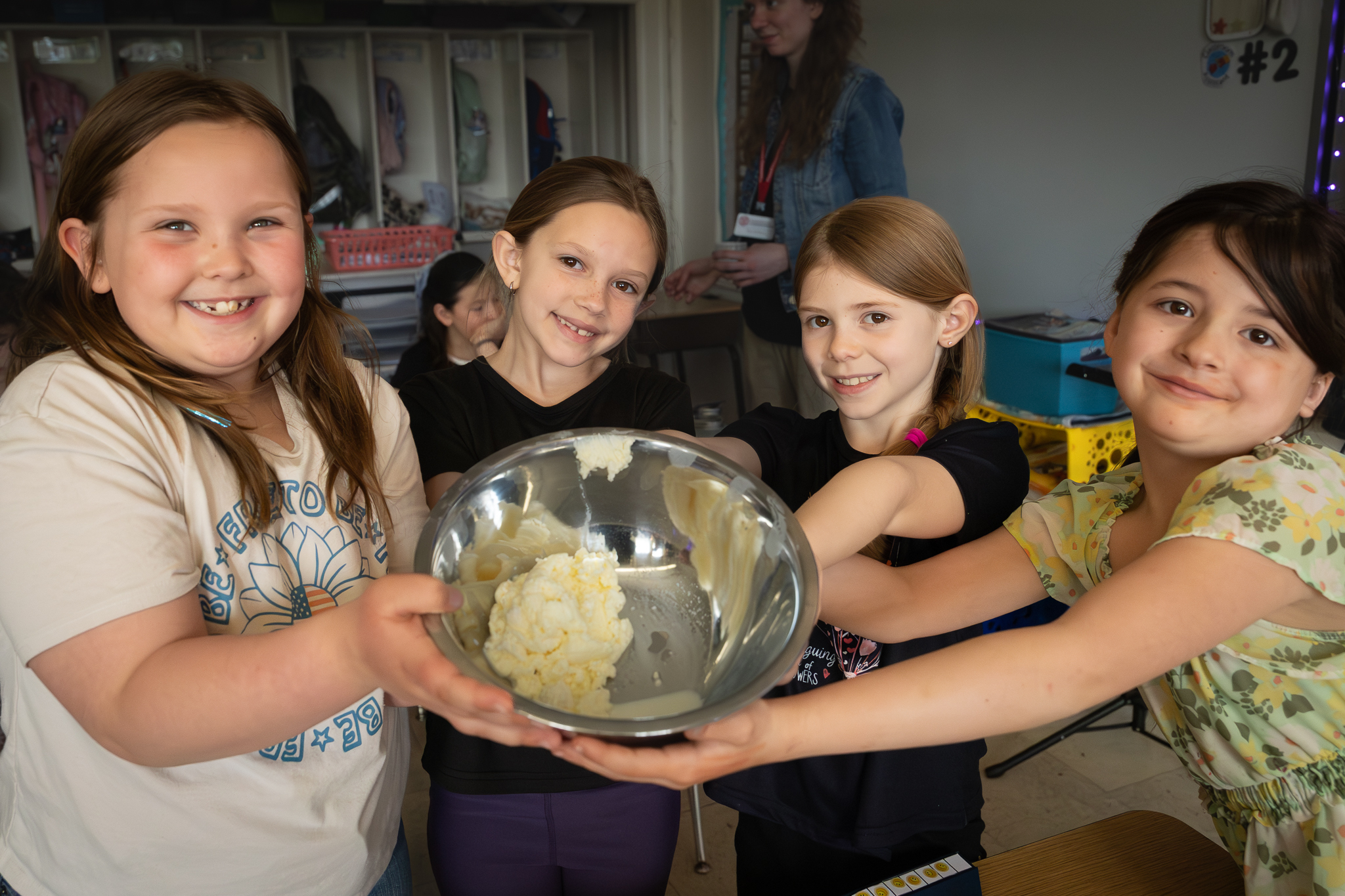 Children baking together with a metal mixing bowl