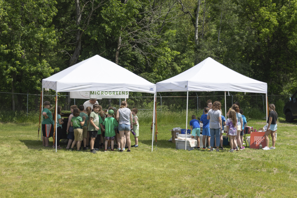 Outdoor event tents with people and microgreens sign